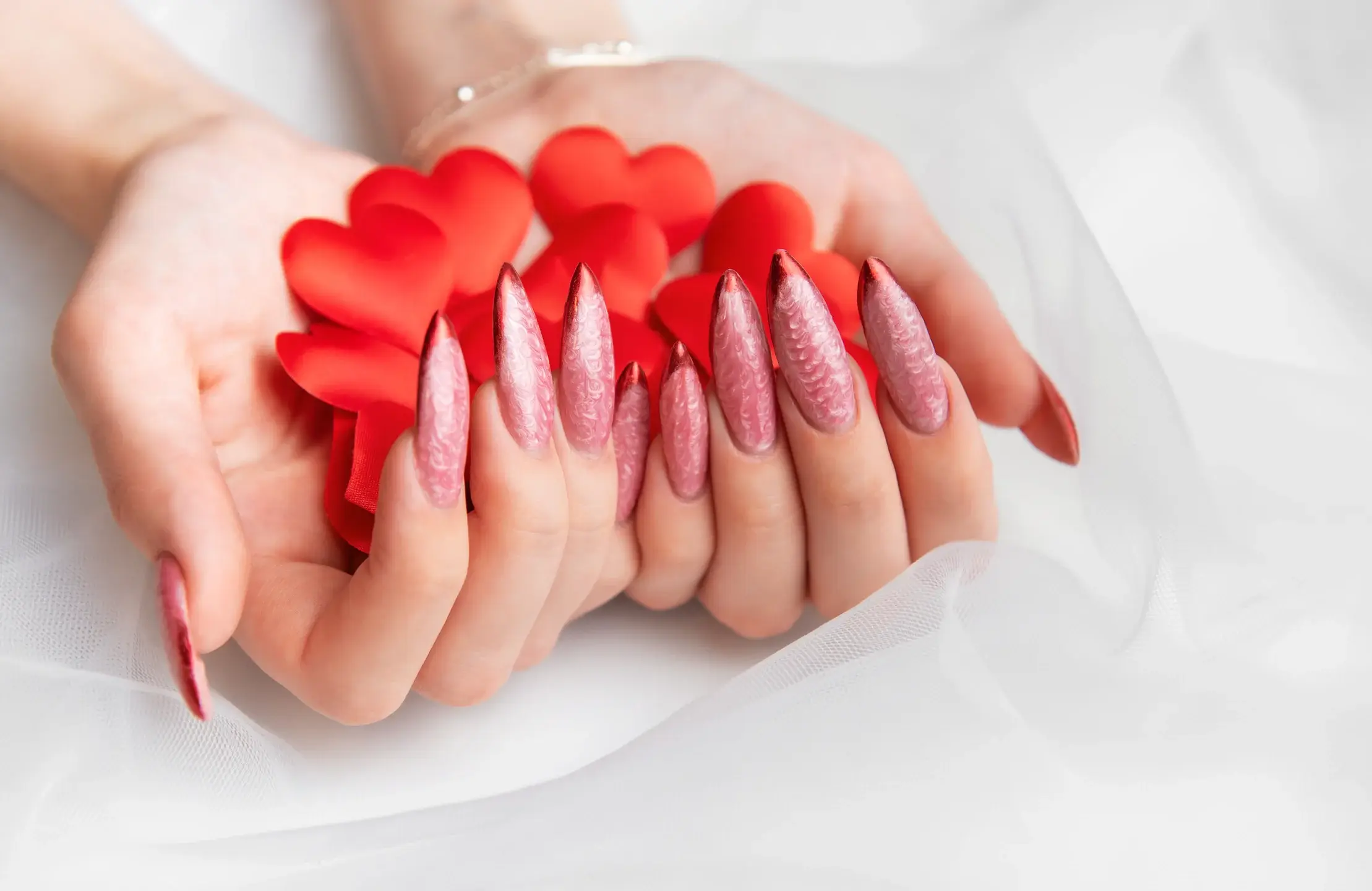 Hands holding red hearts with elegant pink nails 2026 03 08 00 12 28 utc